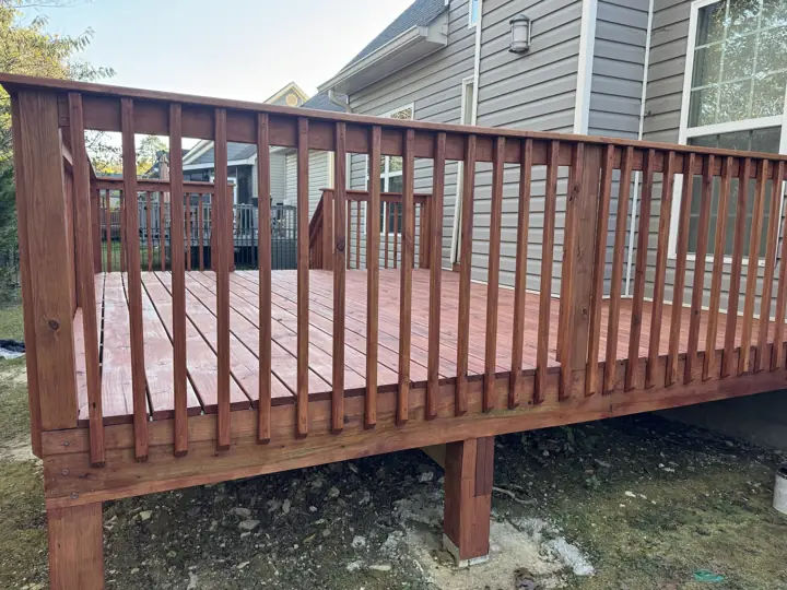 Side of a cedar-tone stained deck showing balusters, rim board and post in Chattanooga, TN