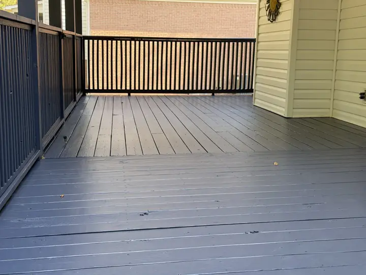 Close view of charcoal-gray stained porch floor boards and railing in Hixson, TN