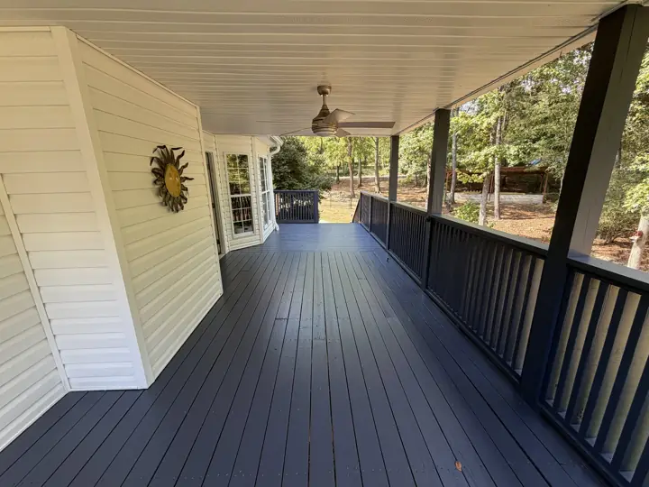 Long covered porch with charcoal-gray stained floor and railing under a white ceiling in Hixson, TN