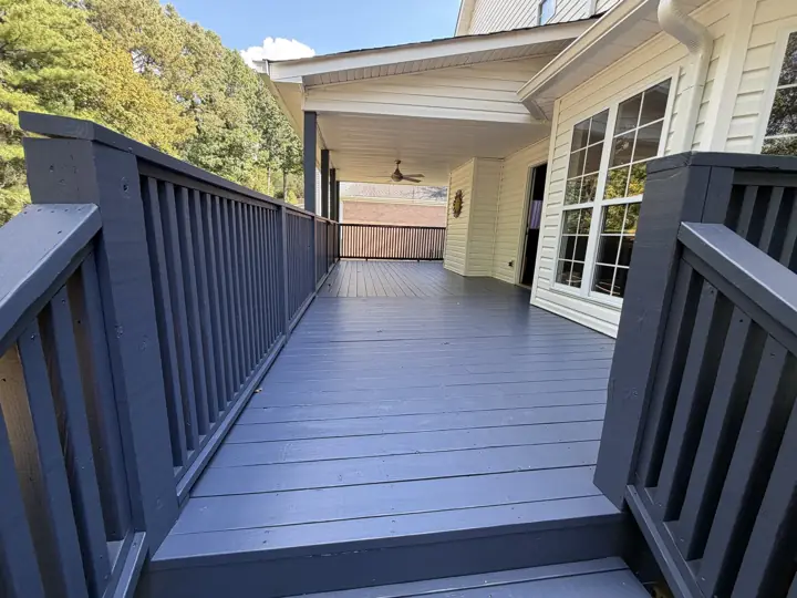 Charcoal-gray deck walkway and railings beside yellow siding in Hixson, TN