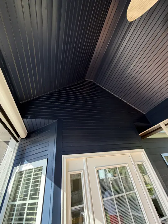 Vaulted beadboard porch ceiling painted deep navy above white French doors in Ooltewah, TN