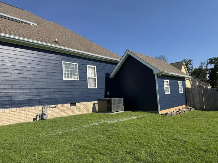 Long side wall and garage in deep navy siding with white window trim in Ooltewah, TN