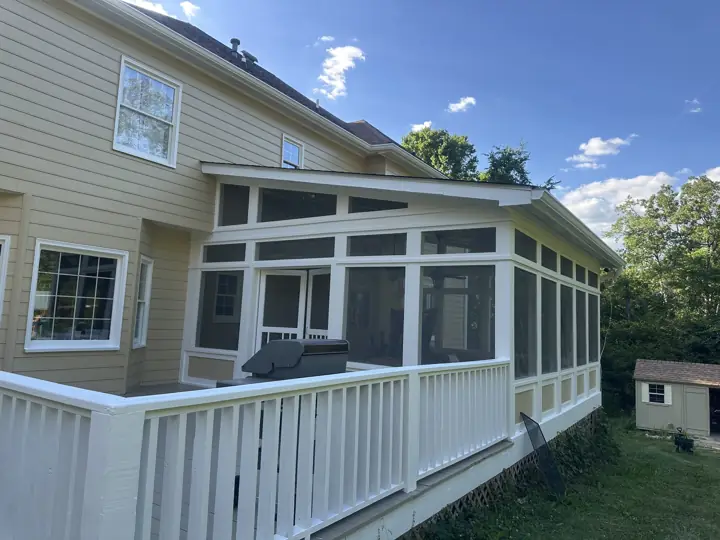White screened porch and deck railing against tan siding after exterior painting in Signal Mountain, TN