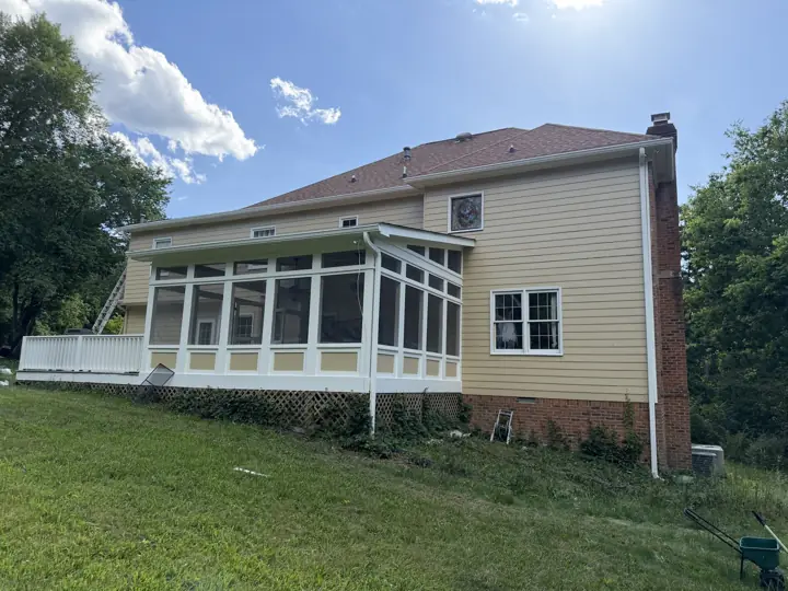 Rear of a two-story home with tan siding and white screened porch after painting in Signal Mountain, TN