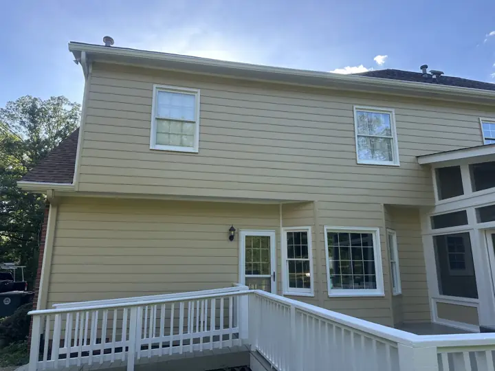 Two-story tan siding wall with white windows and deck railing in Signal Mountain, TN