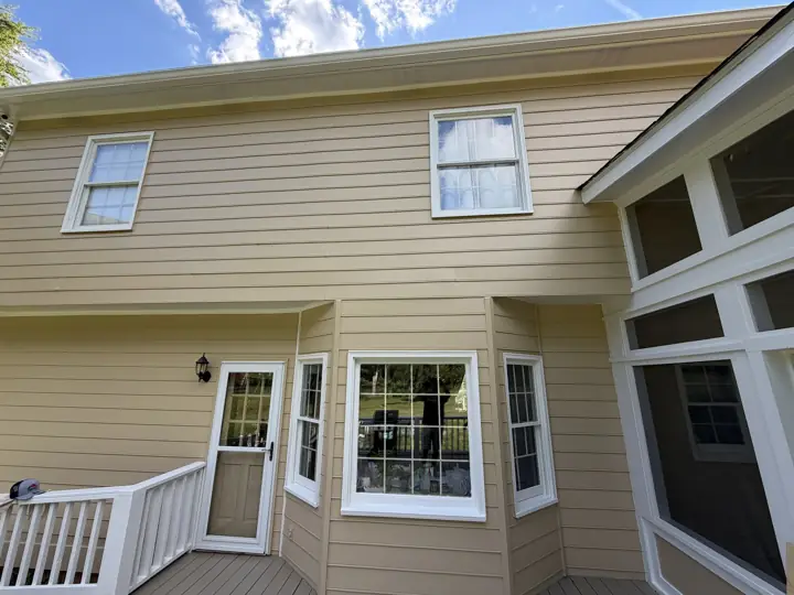 Tan siding with white bay window trim and rear door after exterior painting in Signal Mountain, TN