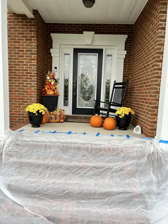 Front porch steps covered in plastic sheeting during trim painting in Ooltewah, TN