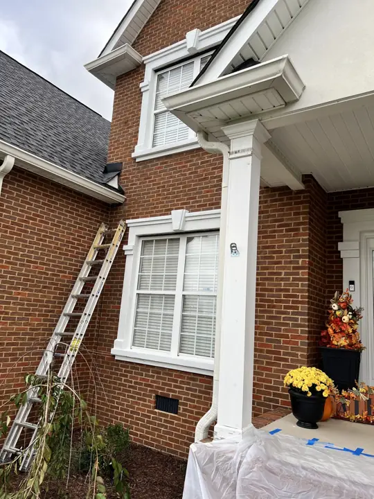 Ladder against brick near the front porch during trim prep in Ooltewah, TN