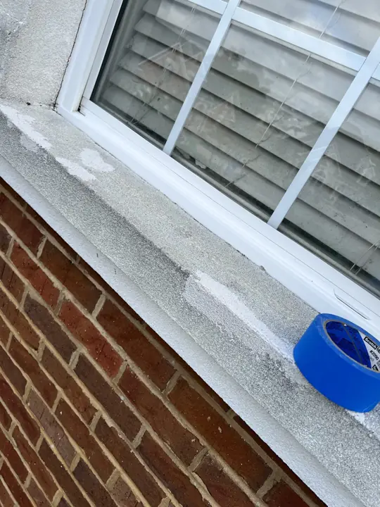 Worn window sill partly coated in white during exterior painting in Ooltewah, TN