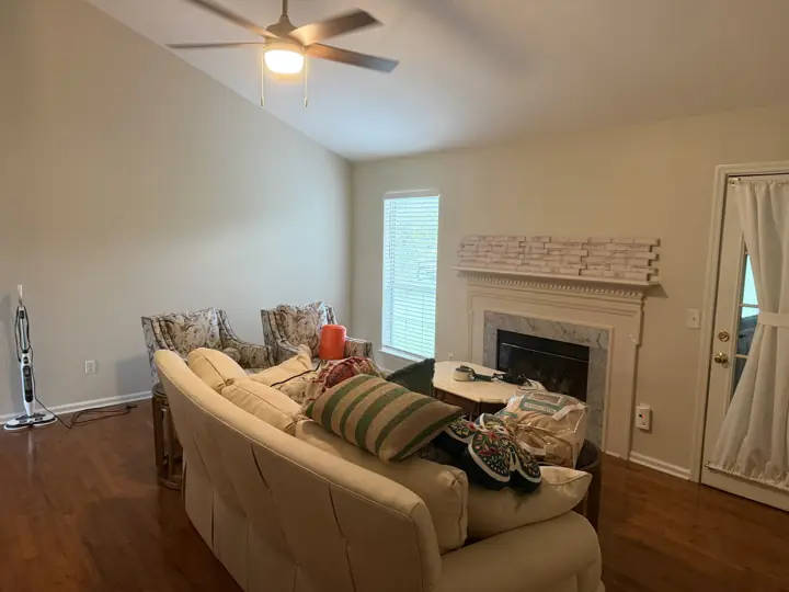 Vaulted living room with warm light walls, white baseboards and fireplace, Apison, TN