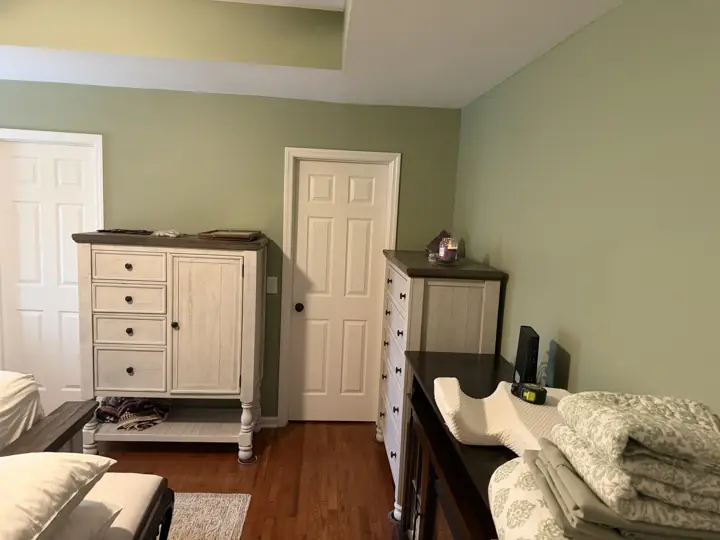 Sage green bedroom walls with white six-panel doors and casings, Apison, TN