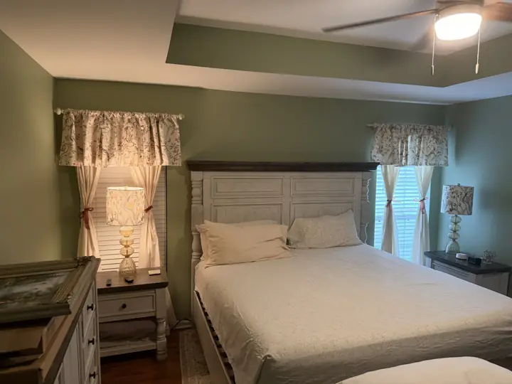 Sage green bedroom wall behind the bed, with the tray ceiling band in matching green, Apison, TN