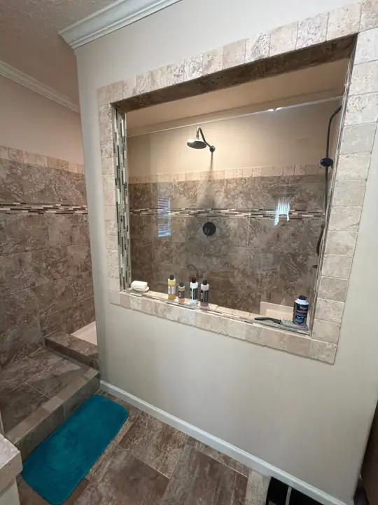 Cream painted walls around a tiled walk-in shower with white baseboard in Cleveland, TN