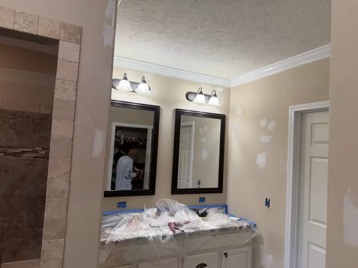 Patched bathroom walls and plastic-wrapped vanity during interior painting prep in Cleveland, TN