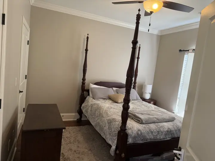 Greige bedroom with four-poster bed, white crown molding and white doors in Hixson, TN