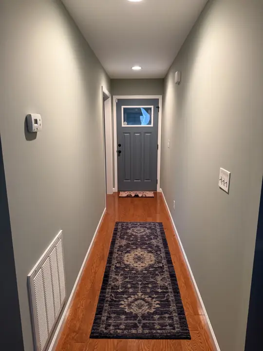 Entry hallway in sage green with white trim and slate gray front door in Cleveland, TN