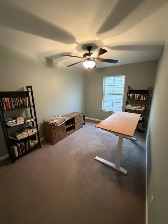 Home office with sage green walls, ceiling fan and bookshelves in Cleveland, TN