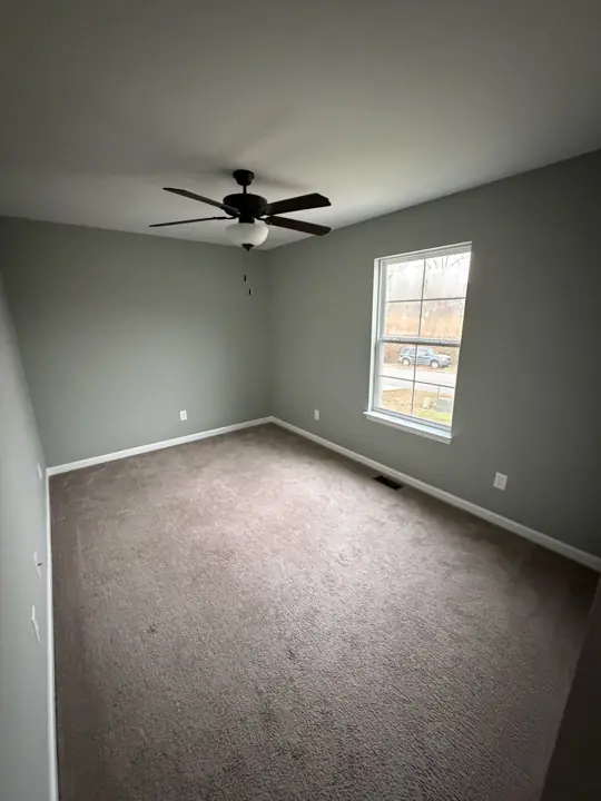Empty bedroom with sage green walls and white baseboards in Cleveland, TN