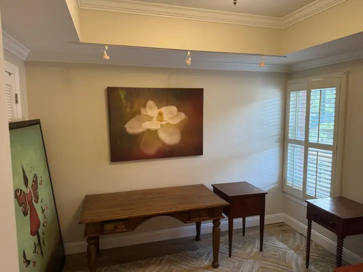 Cream living room wall with white crown molding, shutters and artwork, Chattanooga, TN