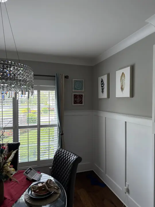 Dining room with white panel wainscoting, gray walls and crystal chandelier in Ooltewah, TN