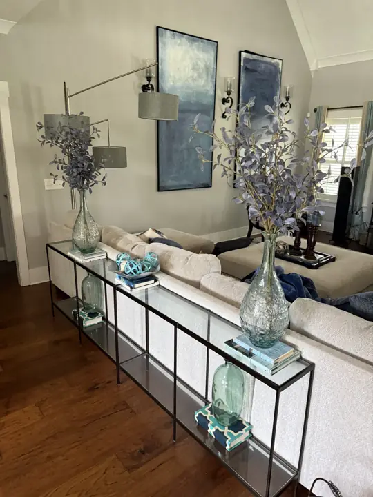 Living room with light gray walls, sconces and blue abstract canvases in Ooltewah, TN
