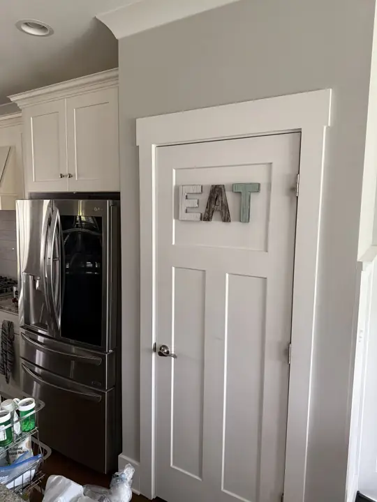 White craftsman pantry door and wide casing against gray kitchen wall in Ooltewah, TN