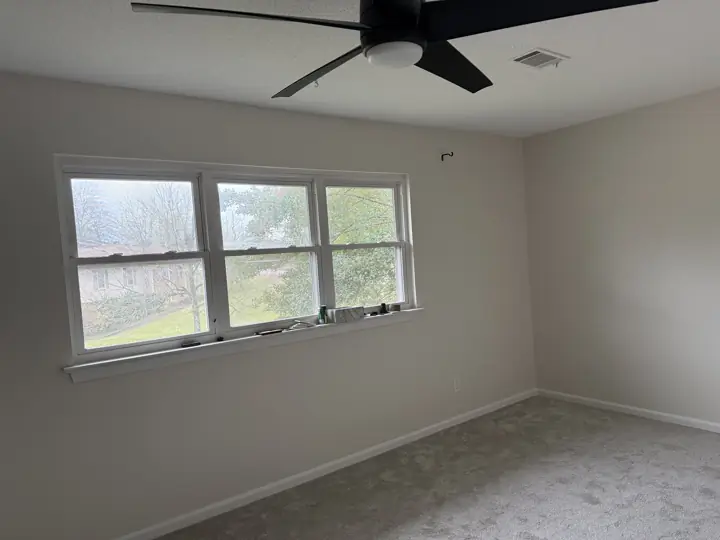 Warm cream bedroom walls around a wide white-trimmed window in Hixson, TN
