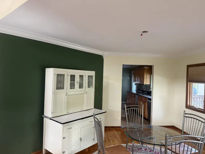 Forest green accent wall behind a white hutch with cream walls and crown molding in Coalmont, TN