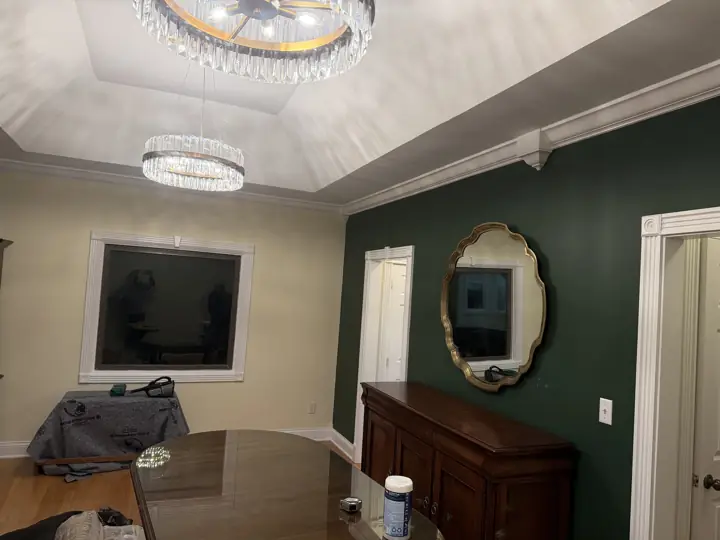 Dining room forest green accent wall with gold mirror under a white tray ceiling in Coalmont, TN