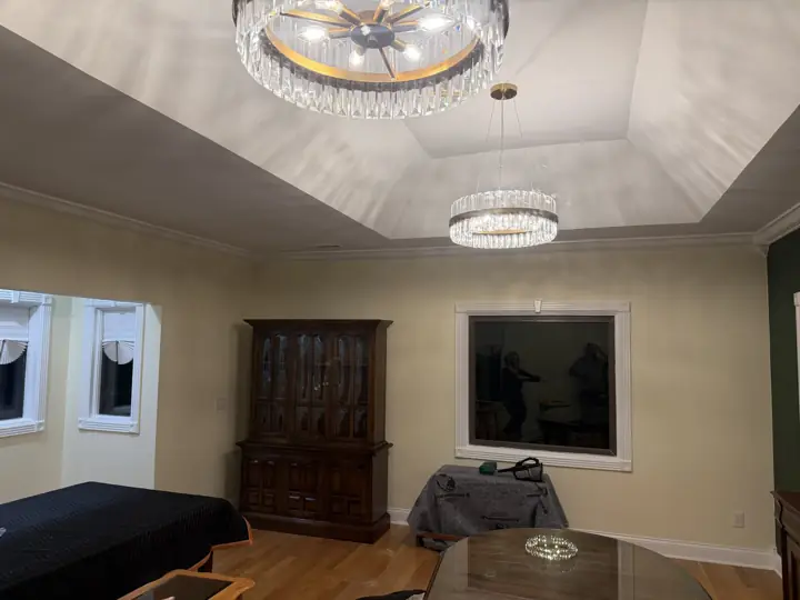 Dining room tray ceiling painted white with crystal chandeliers and cream walls in Coalmont, TN