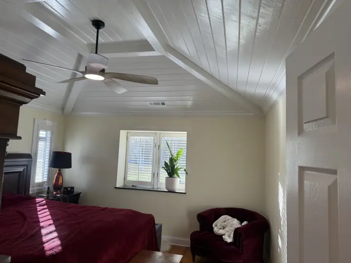 Primary bedroom with vaulted white plank ceiling, white beams and cream walls in Coalmont, TN