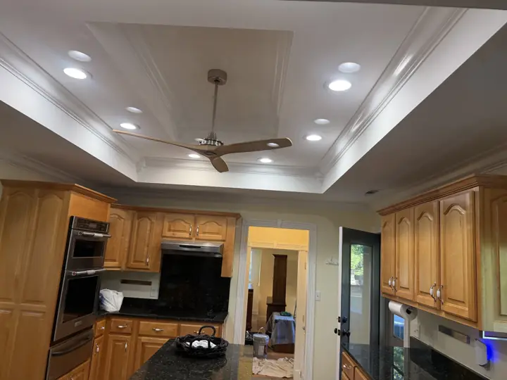 Kitchen with stepped tray ceiling and crown molding painted white above wood cabinets in Coalmont, TN