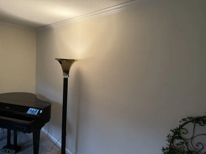 Long cream living room wall with white crown molding behind a piano in Harrison, TN