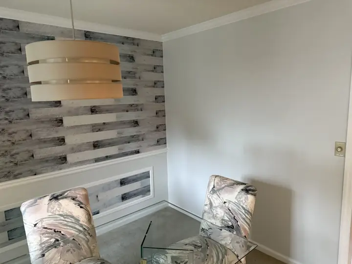 Corner of pale gray dining room with white crown molding and panel molding in Harrison, TN