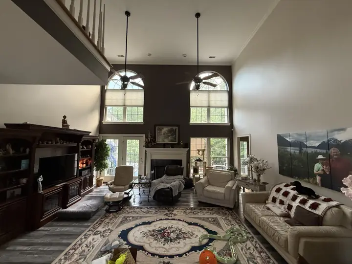 Wide view of a two-story living room with charcoal accent wall and gray walls in Hixson, TN