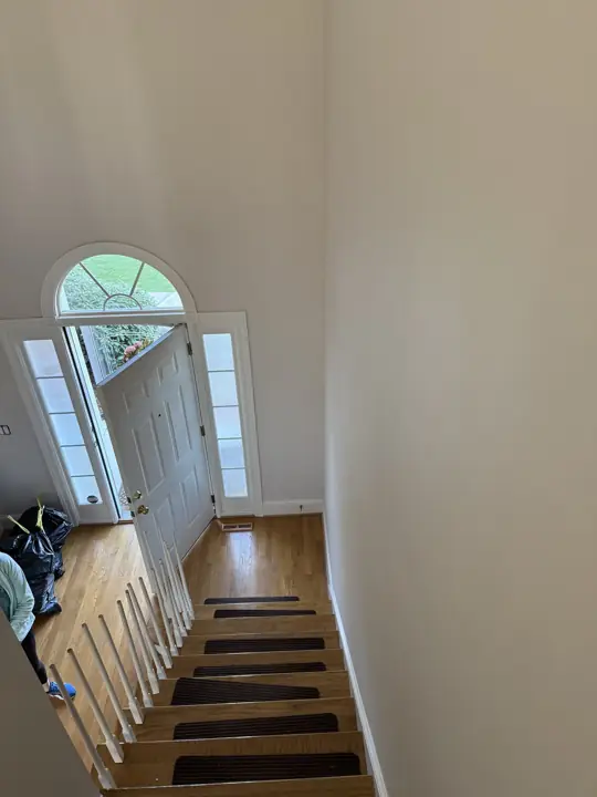 Foyer stairwell with light gray walls and arched front door in Hixson, TN