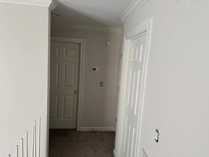 Upstairs hallway with light gray walls, white doors and crown molding in Hixson, TN