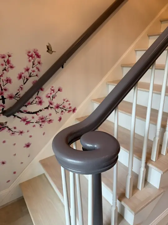 Pewter-painted stair handrail volute with white balusters in Hixson, TN