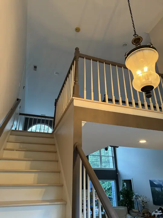Stairwell with light walls and loft railing under a lantern pendant in Hixson, TN