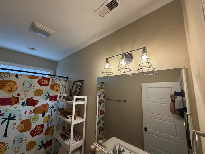 Tan bathroom wall with vanity light and mirror in Chattanooga, TN
