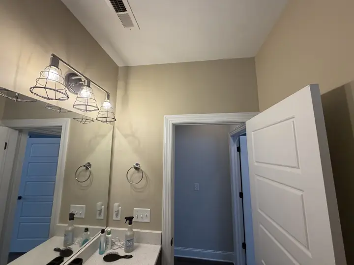 Warm tan bathroom walls with white door casing and five-panel door in Chattanooga, TN