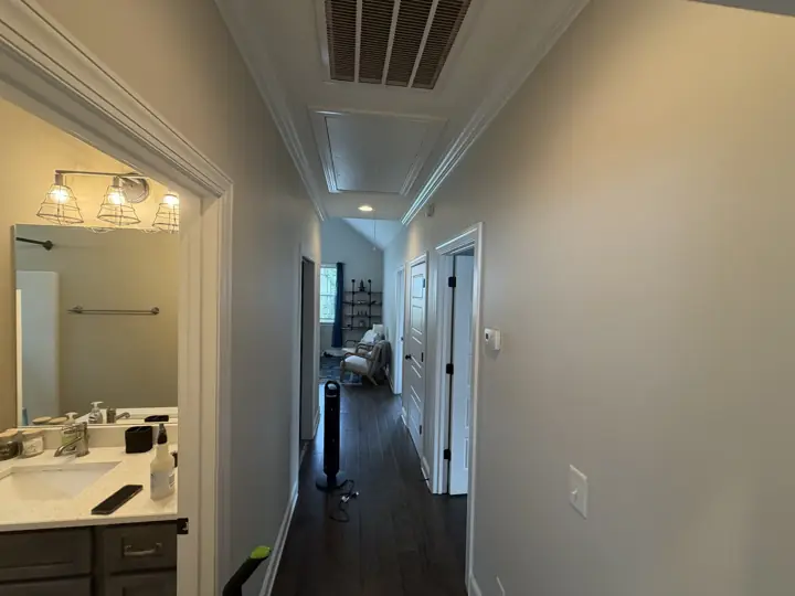 Long hallway with greige walls, white crown molding and white door casings in Chattanooga, TN