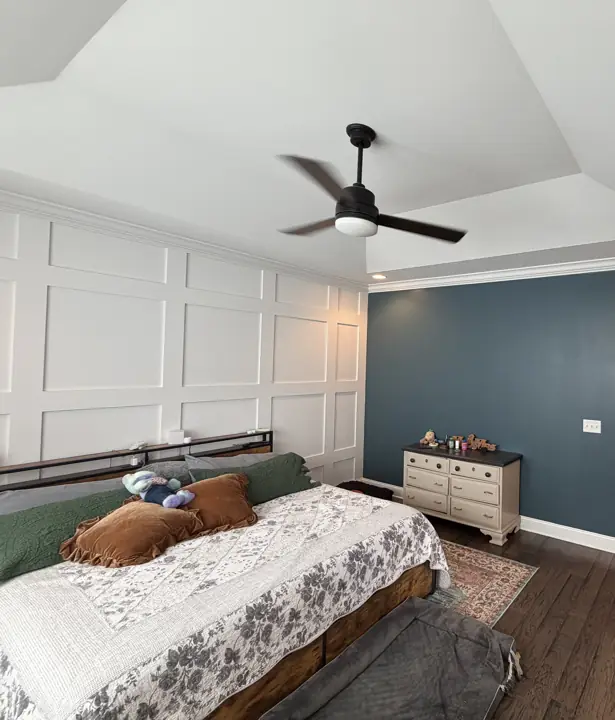 Navy bedroom wall beside a white grid-paneled accent wall under a tray ceiling in Chattanooga, TN