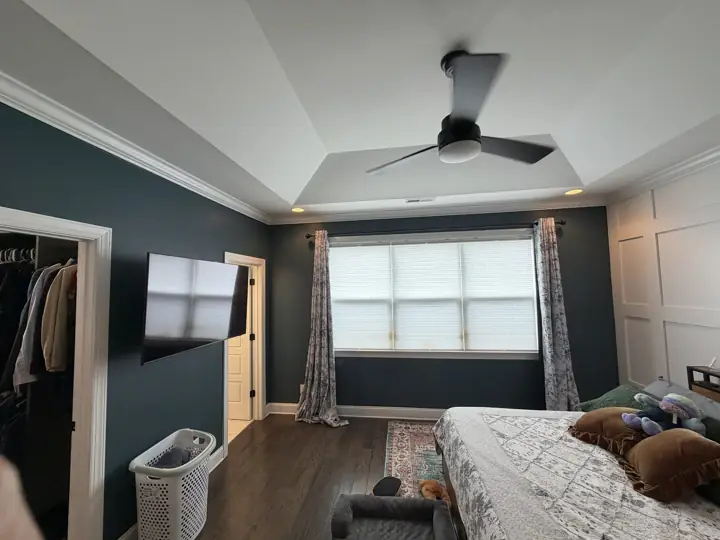 Deep navy primary bedroom with white tray ceiling, crown molding and door casings in Chattanooga, TN