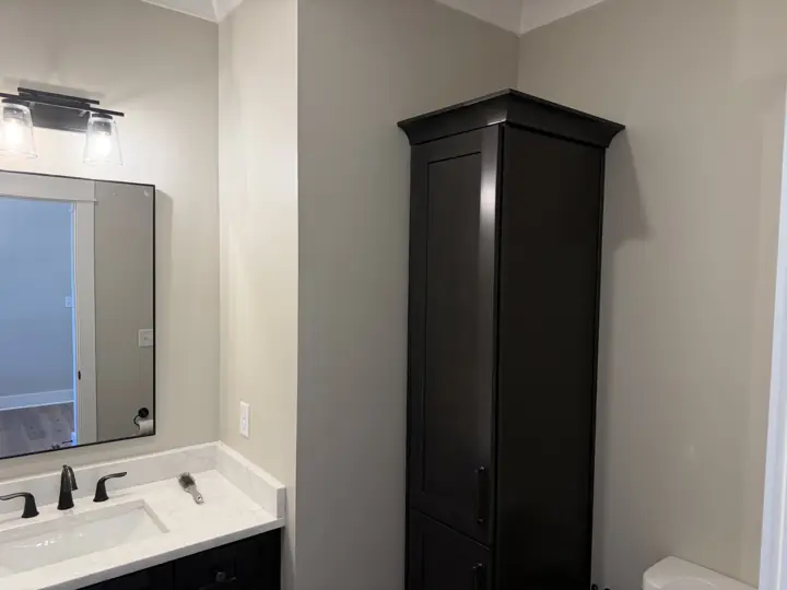 Bathroom with warm greige walls beside a dark linen cabinet and vanity, Soddy-Daisy, TN