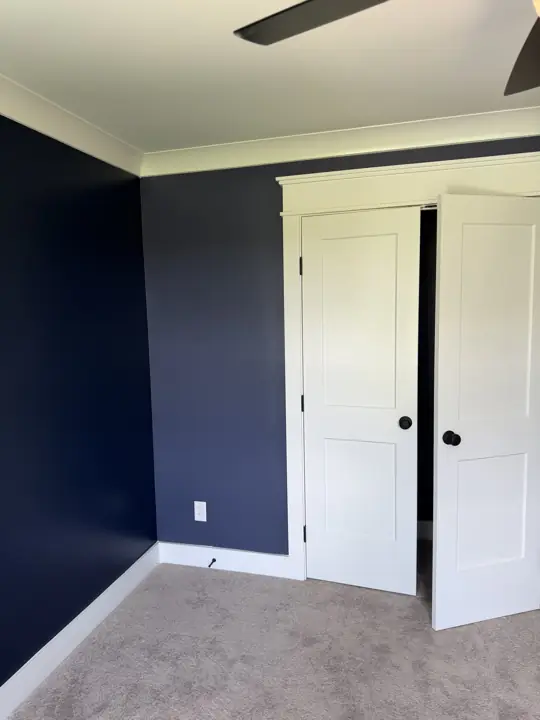 Navy bedroom wall beside white closet doors and trim, Soddy-Daisy, TN