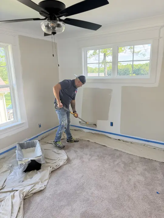 Painter using an extension roller near the baseboard with carpet covered, Soddy-Daisy, TN