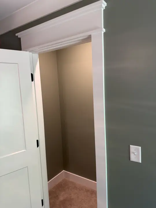 Walk-in closet opening with white header trim in a sage green bedroom, Soddy-Daisy, TN