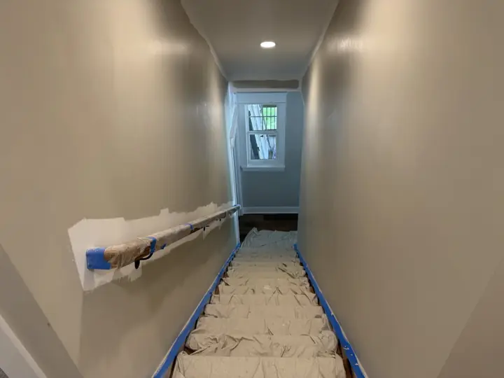 Stair treads covered with drop cloths and taped edges before stairwell painting, Soddy-Daisy, TN