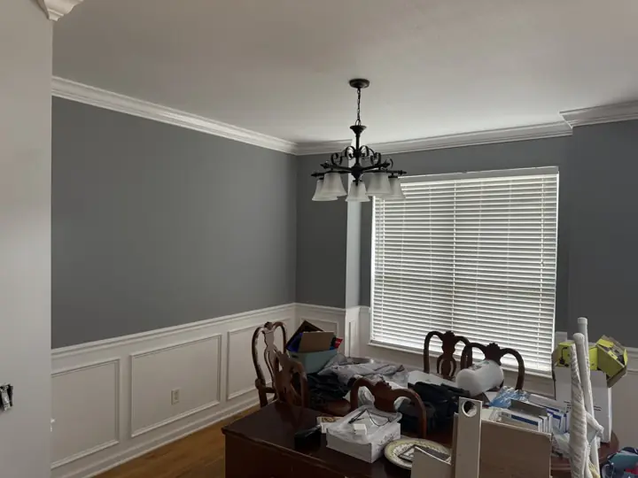 Dining room with slate gray walls above white picture-frame wainscoting and crown molding in Ooltewah, TN